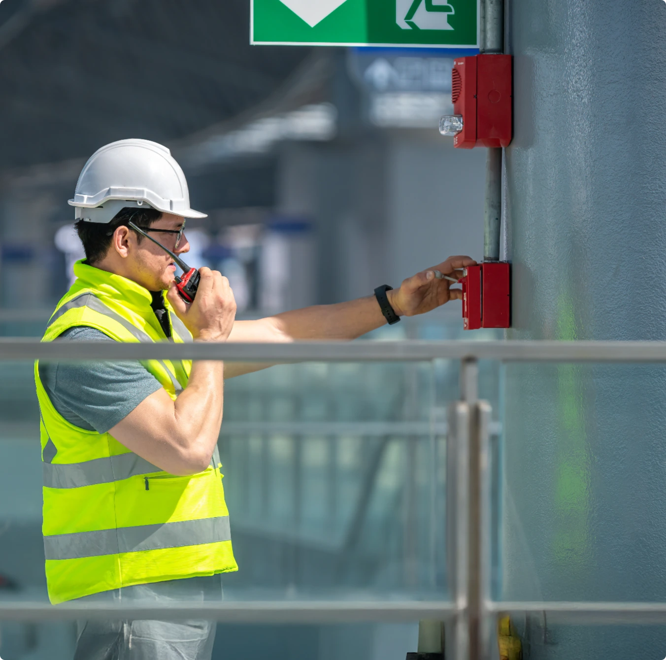 Safetec Protection technician tests a fire alarm call point with a radio, showcasing professional Fire Safety Services for commercial buildings daily.
